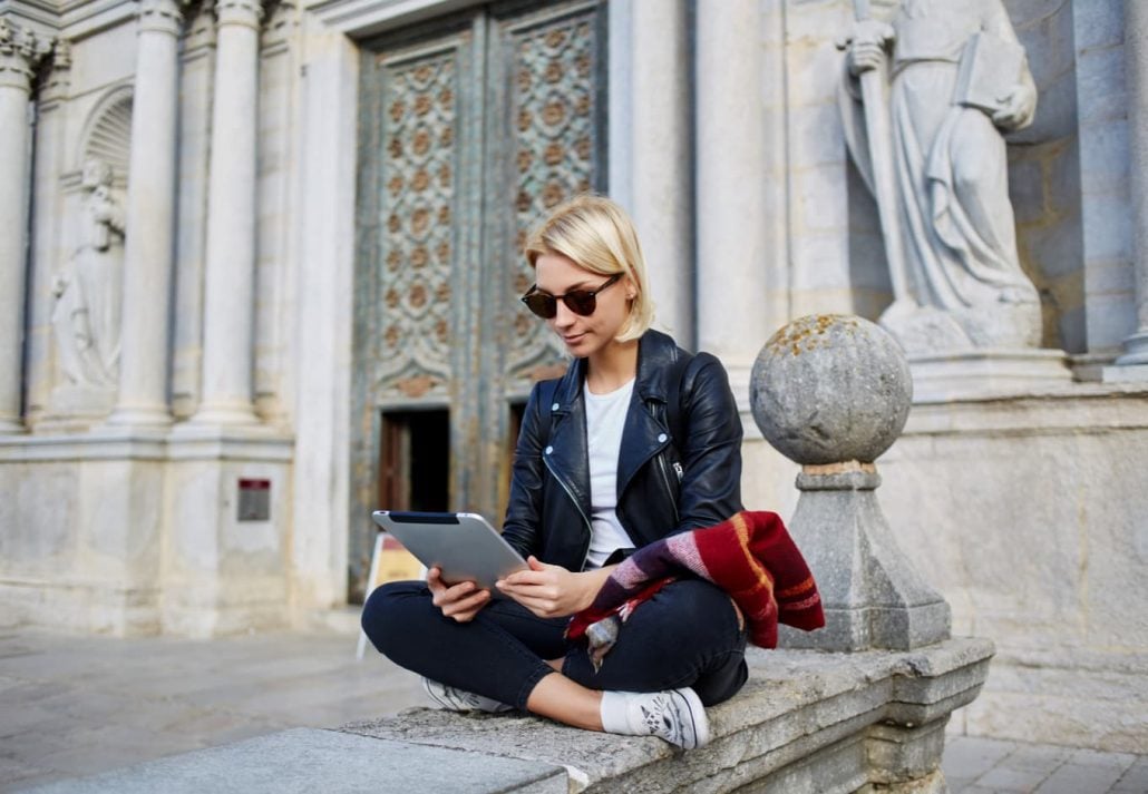 Young woman using her touch pad in Rome.